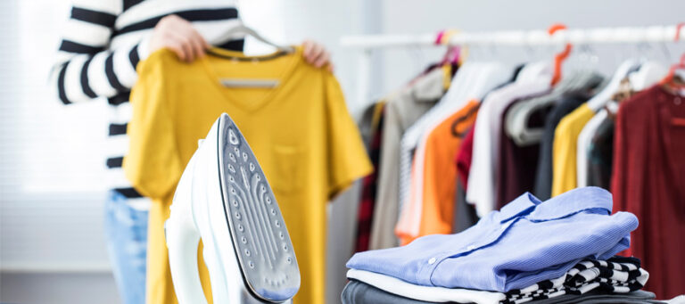 Ironed Shirts, Steam Generating Iron, Lady holding ironed blouse on hanger